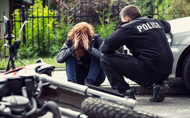 Police officer consoling the victim of a motorcycle accident